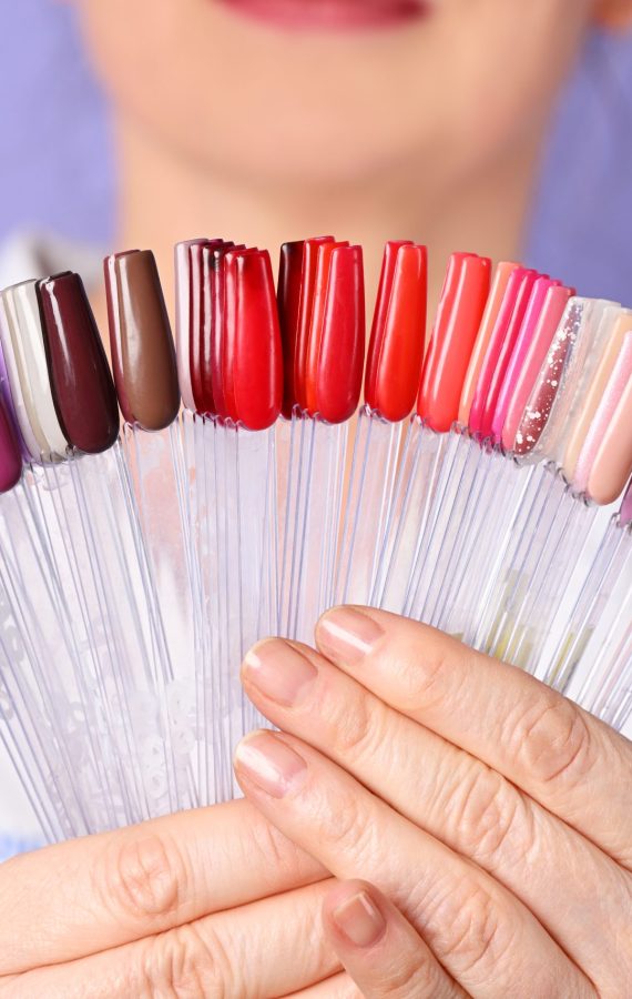 Female beautician holding nail polish palette set for manicure Female beautician holding colorful nail polish palette set for manicure